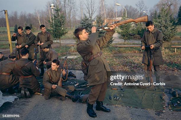 Yugoslavian Federal Army soldier aims a rifle at his forehead at a military base in Banja Luka during the Yugoslavian Civil War.