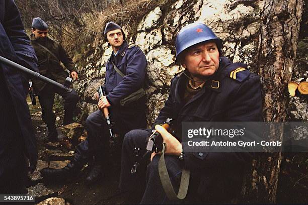 Bosnian militiamen wearing Serbian uniforms rest in Sarajevo's heights.