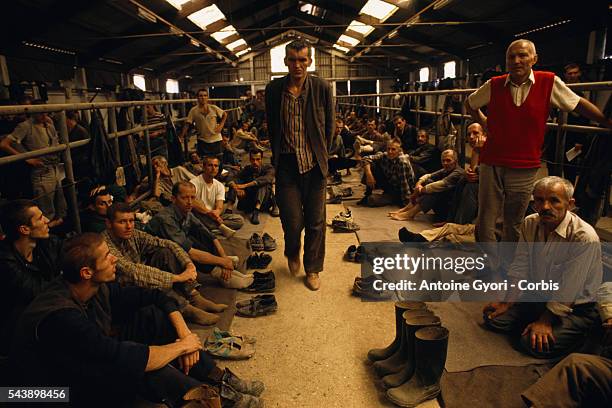 Emaciated Bosnian prisoners of war are detained in a crowded confinement cell at the Manjaca concentration camp during the Yugoslavian Civil War. The...