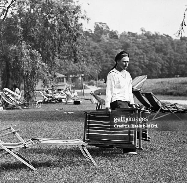 German Empire Free State Prussia - Brandenburg Provinz - Berlin: Assistant in seaman-outfit is carrying canvas chairs -club ' Klub am Rupenhorn ' at...