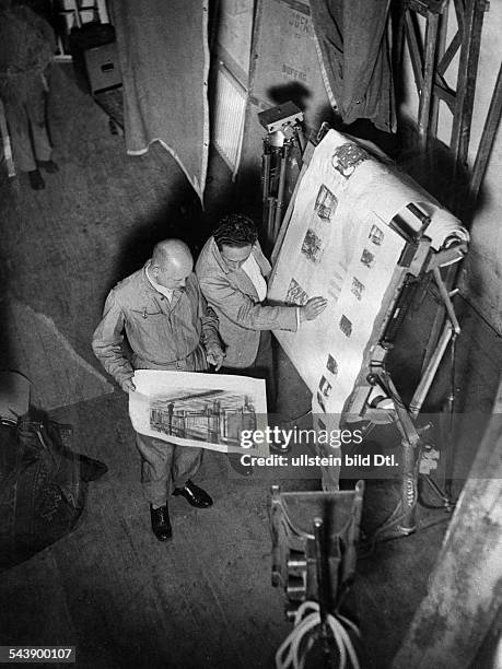 Preparations for shooting: the director discusses by the storyboard the structure of the film set for a scene with a set designer - undated, about...