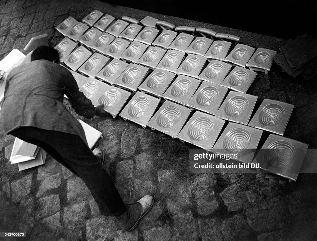 Man laying out stove tiles on the floor - Photographer: Ullmann- Published by: 'Hier Berlin' 14/1936Vintage property of ullstein bild