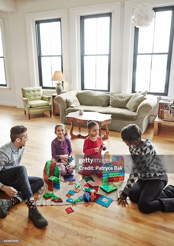 Transgender dad plays with his daughters in living