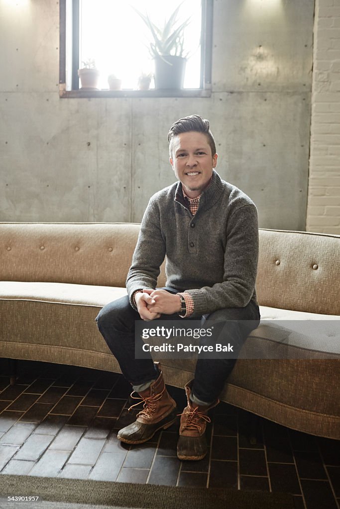 Stylish transgender man in modern living room