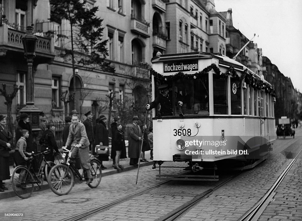 Wedding streetcar is passing throught the streets of Friedenau decorated with festoons and swastika flags at the occasion of the wedding of an employee - Photographer: Herbert Hoffmann- Published by: 'Berliner Morgenpost' 15.04.1936Vintage property o