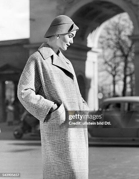 Model dressed in a coat with a checkered pattern and a modern fedora hat - ca. 1956- Photographer: Regine Relang- Published by: 'Brigitte'...