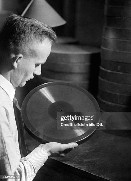 Man looking at wax record - Photographer: Curt Ullmann- Published by: 'Hier Berlin' 43/1937Vintage property of ullstein bild