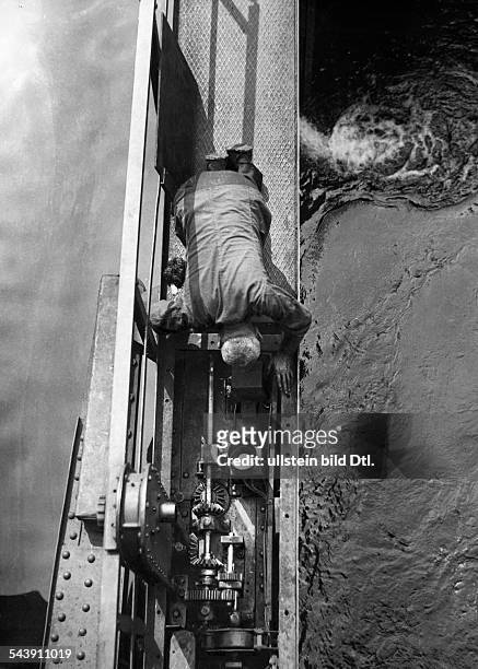 German Empire Free State Prussia Berlin: Lock at the 'Muehlendamm', a man lubricating the gear of the lock - Photographer: Curt Ullmann- Published...
