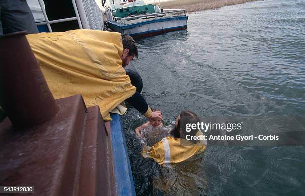 Father Guenadi baptises a child in the Volga.