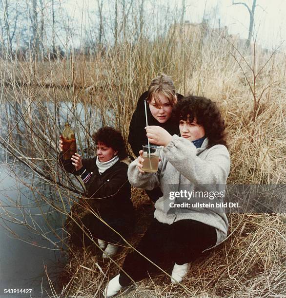 Schülerinnen der 10.Klasse einerpolytechnischen Oberschule bei derEntnahme einer Wasserprobe einesMoorteiches bei Stralsund .April 1984