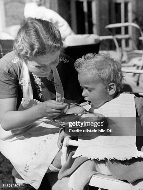 German Empire Free State Prussia Brandenburg Province : in the German residential school in Hermannswerder near Potsdam: a nursery nurse feeding a...