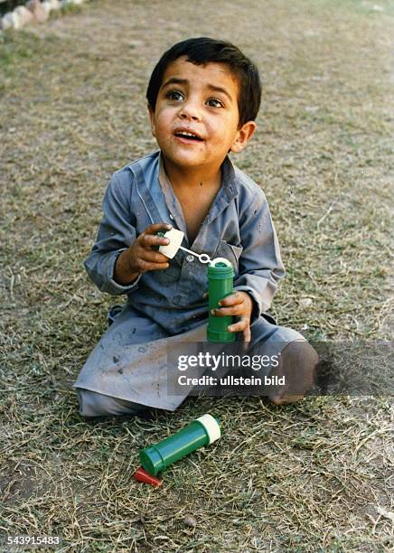 Afghanistan, Amputierter Junge macht Seifenblasen- 1986