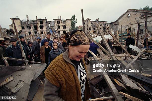 Civilians come back to the main Grozny market after its destruction by a Russian missile, the day before.