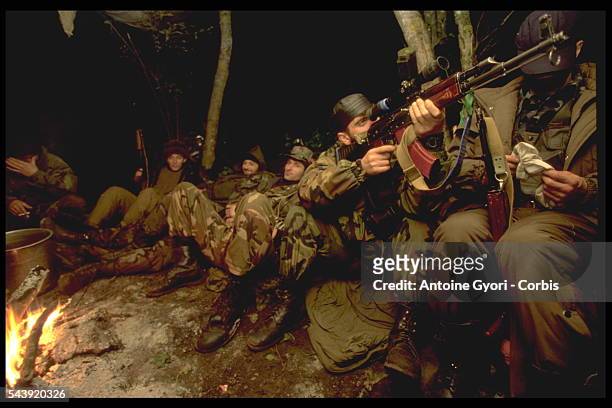 Chechen frontline fighters around a fire.