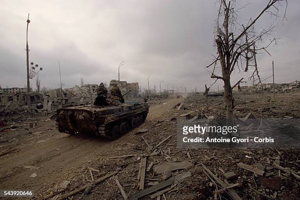 Russian soldiers roll through the bombed city of Grozny after intense fighting in the Second Chechen War.