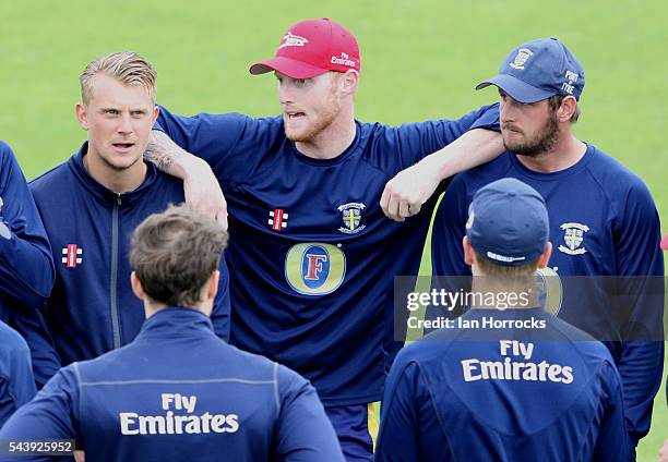 Ben Stokes of Durham leans on team-mate Phil Mustard and Scott Borthwick whilst warming up during the NatWest T20 Blast game between Durham Jets and...