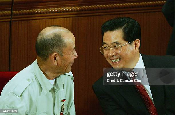 Chinese President Hu Jintao talks with war veteran Chen Zhonglai during a meeting marking the 60th anniversary of the victory of China's Resistance...