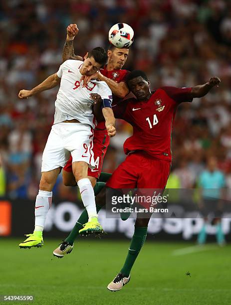 Robert Lewandowski of Poland competes for the ball against Jose Fonte and William Carvalho of Portugal during the UEFA EURO 2016 quarter final match...