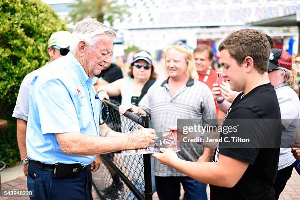 Bobby Allison, NASCAR Hall of Famer, signs autographs during practice for the NASCAR Sprint Cup Series Coke Zero 400 at Daytona International...