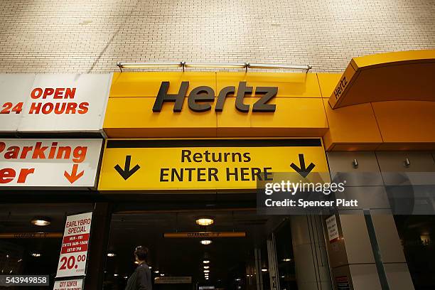 Hertz car rental agency stands in Manhattan on June 30, 2016 in New York City. In an effort to expand its presence in the ride-hailing business,...