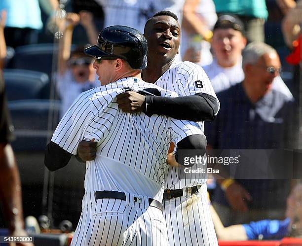 Chase Headley of the New York Yankees is congratulated by teammate Didi Gregorius after Headley scores on a passed ball in the ninth inning against...