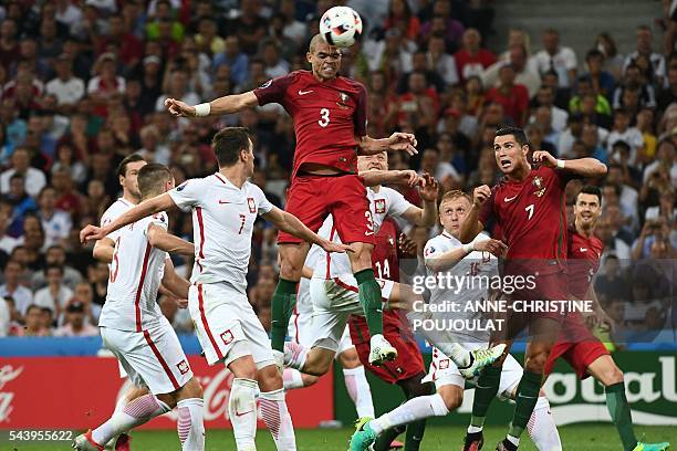 Portugal's defender Pepe jumps for the ball next to Poland's forward Arkadiusz Milik during the Euro 2016 quarter-final football match between Poland...