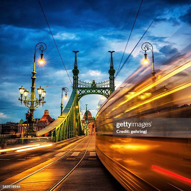 moving-straßenbahn auf der freiheitsbrücke in budapest - hungary stock-fotos und bilder