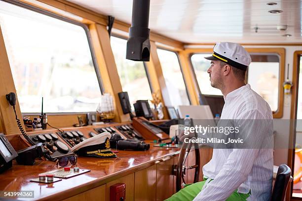 young captain steering boat - roer stockfoto's en -beelden