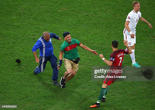 An invading fan tries to hug Cristiano Ronaldo of Portugal during the UEFA EURO 2016 quarter final match between Poland and Portugal at Stade...