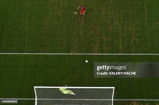 Portugal's forward Cristiano Ronaldo shoots and scores the first in a penalty shoot-out during the Euro 2016 quarter-final football match between...