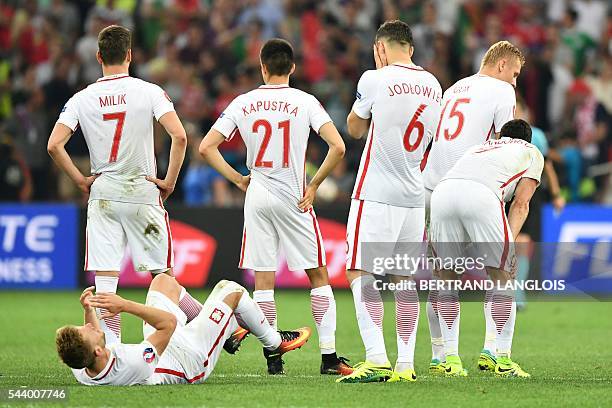 Poland's players reacts after losing the Euro 2016 quarter-final football match between Poland and Portugal at the Stade Velodrome in Marseille on...