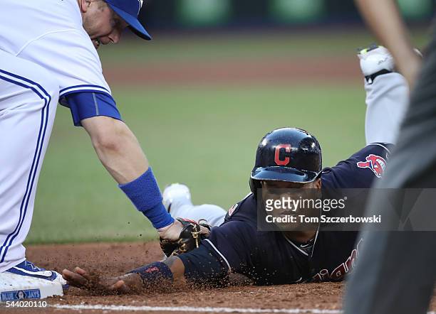 Jose Ramirez of the Cleveland Indians is picked off first base in the sixth inning during MLB game action as Justin Smoak of the Toronto Blue Jays...