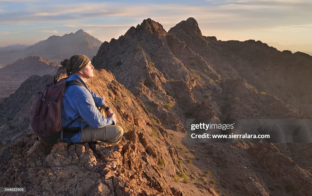 Hiker Meditating on top of Mountain