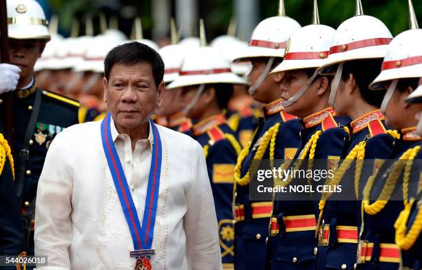 Philippine President Rodrigo Duterte walks past honour guards before Philippine National Police chief Ronald "Bato" Dela Rosa's Assumption of Command...