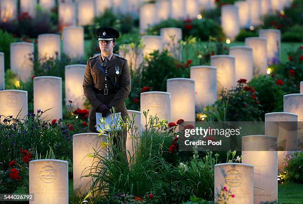 View of a soldier amongst military graves illuminated during part of a military-led vigil to commemorate the 100th anniversary of the beginning of...