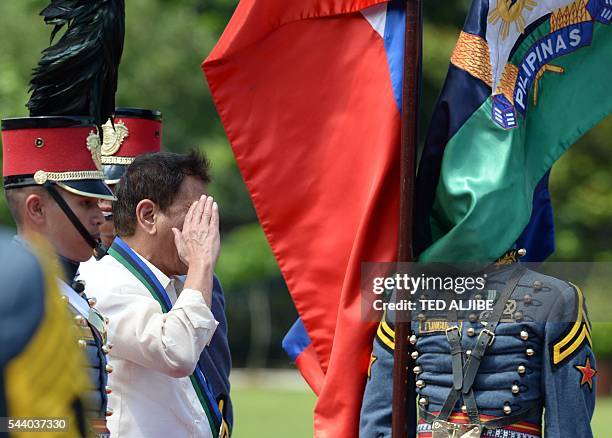 Philippines President Rodrigo Duterte salutes as he review troops during a military parade at the military headquarters in Manila on July 1, 2016....