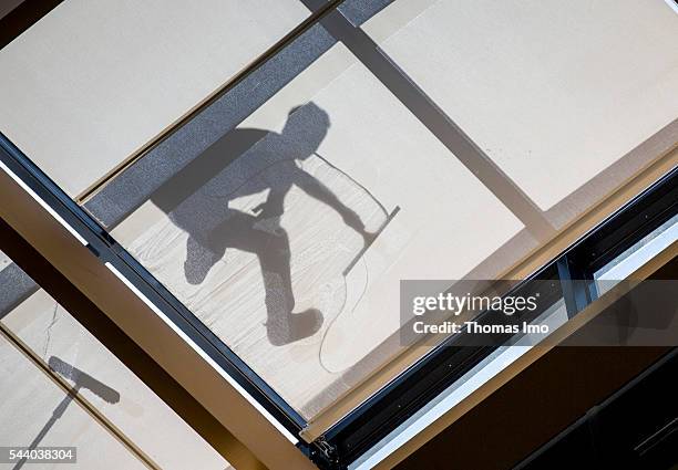 Berlin, Germany Shadow of a worker who cleans a glass roof on June 23, 2016 in Berlin, Germany.