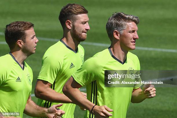 Mario Goetze, Shkodran Mustafi and Bastian Schweinsteiger of Germany runs during a Germany training session ahead of their Euro 2016 quarter final...