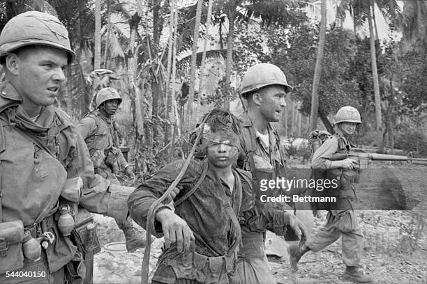 Bong Son, South Vietnam - Two soldiers of the U. S. First Cavalry Division drag a Viet Cong from a bunker January 29th during a sweep to the North of...