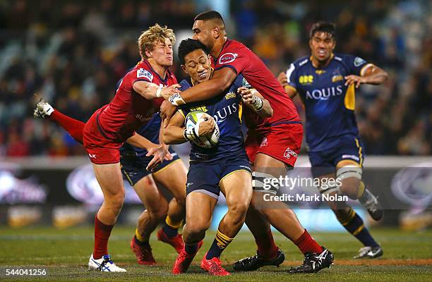 Christian Lealiifano of the Brumbies is tackled during the round 15 Super Rugby match between the Brumbies and the Reds at GIO Stadium on July 1,...