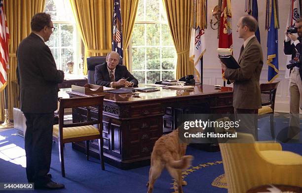 Secretary of State Henry Kissinger and National Security Advisor Brent Scowcroft speak with President Gerald Ford in the Oval Office.