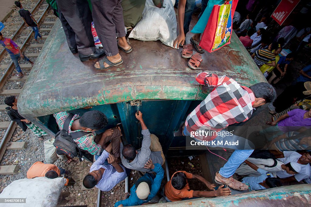 People climb on to the roof of an overloaded train as they...