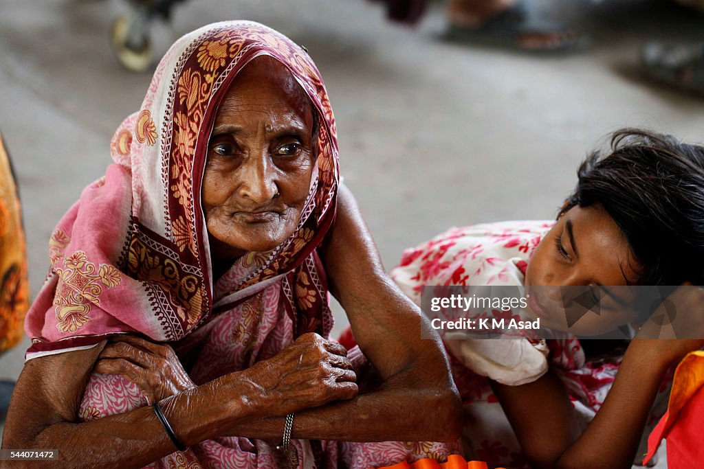 An 80 year old woman takes a rest while she waits for a...