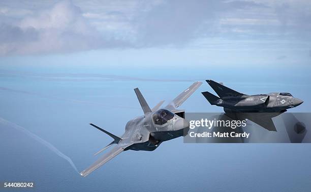 The first of Britain's new supersonic 'stealth' strike fighters accompanied by a United States Marine Corps F-35B aircraft, flies over the North Sea...