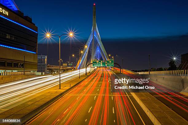 traffic car trails on the zakim bridge at night. boston, ma - boston ma stock pictures, royalty-free photos & images