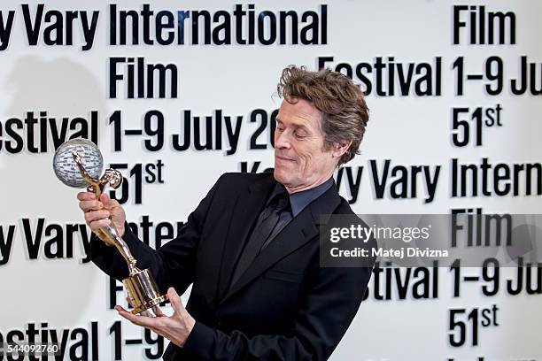 Actor Willem Dafoe poses for photographers with the Crystal Globe Award for Outstanding Artistic Contribution to World Cinema at the opening ceremony...