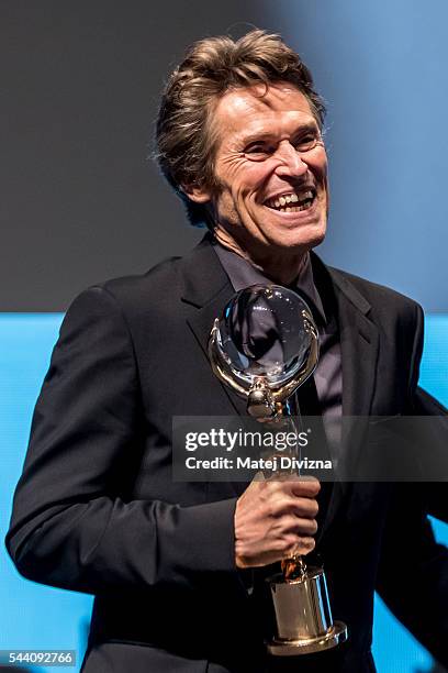 Actor Willem Dafoe holds the Crystal Globe Award for Outstanding Artistic Contribution to World Cinema during the opening ceremony of the 51st...