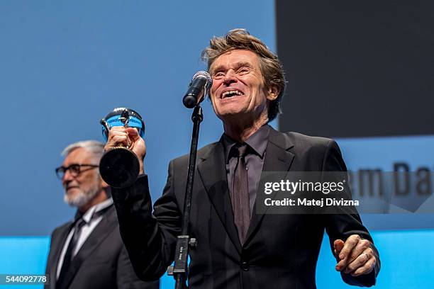 Actor Willem Dafoe holds the Crystal Globe Award for Outstanding Artistic Contribution to World Cinema during the opening ceremony of the 51st...