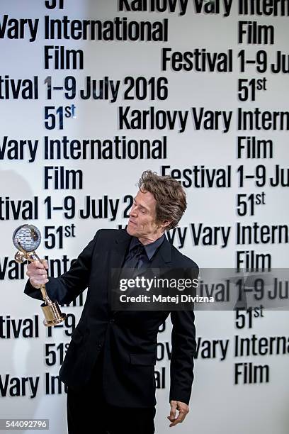 Actor Willem Dafoe poses for photographers with the Crystal Globe Award for Outstanding Artistic Contribution to World Cinema at the opening ceremony...