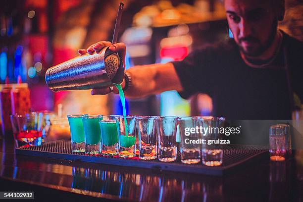 young bartender pouring cocktails in a nightlife bar - hair color saloon stockfoto's en -beelden